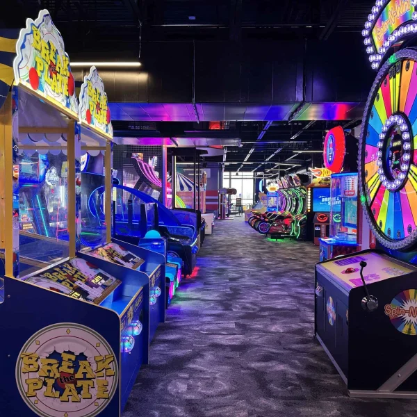 Professional arcade design banner featuring modern game room with colorful claw machines, neon LED lighting, and exciting entertainment center layout