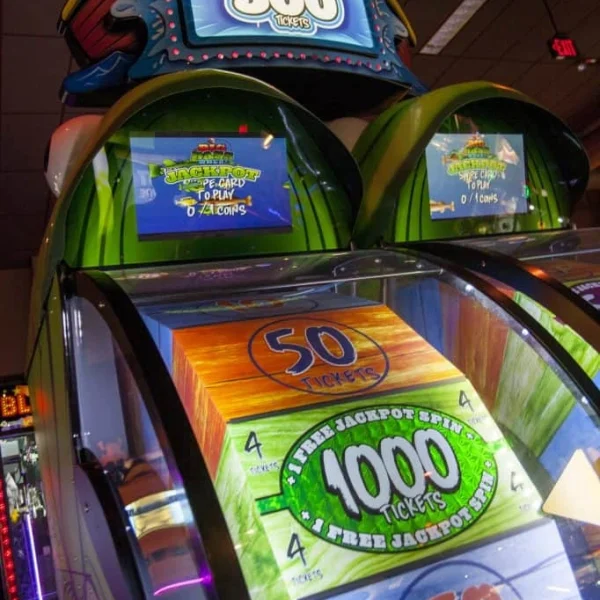 Colorful jackpot ticket redemption arcade machine displaying 500 and 1000 ticket wins with spinning wheel